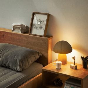 Lampe champignon en bois rechargeable sur une table de chevet
