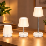 Trois lampes de table LED blanches télescopiques présentées à différentes hauteurs sur une table en bois, dans un intérieur chaleureux.